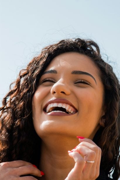 Close-up of a smiling woman with bright white teeth after a LED whitening session in the Philippines.